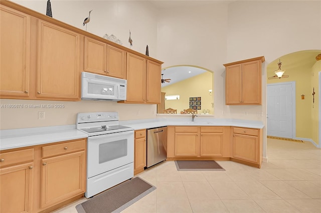 23157 Addison Lakes Cir, Boca Raton, FL 33433 - kitchen with white appliances, arched walkways, light tile patterned floors, and high vaulted ceiling