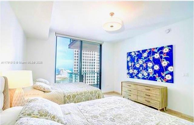 bedroom featuring baseboards and a wall of windows
