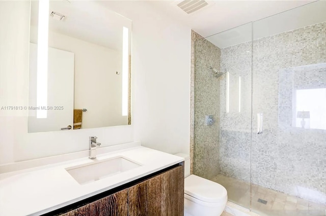 full bathroom featuring toilet, a stall shower, and vanity