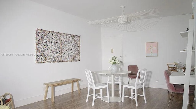 dining space featuring wood finished floors and baseboards