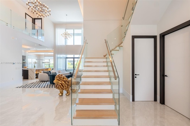 9625 Vescovato Way, Boca Raton, FL 33496 - stairway with a chandelier, a high ceiling, and tile patterned floors