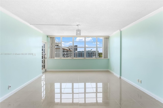 tiled empty room featuring ornamental molding, a textured ceiling, and baseboards