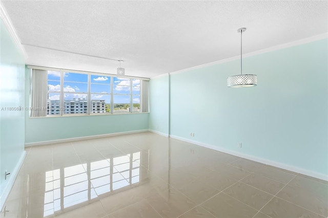 tiled empty room with a textured ceiling and baseboards