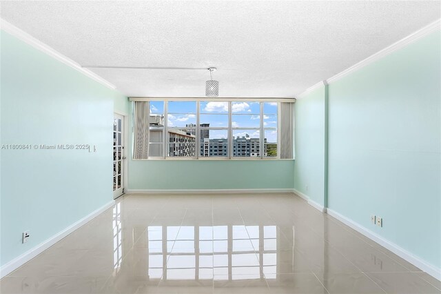 2025 NE 164th St Unit 907, North Miami Beach, FL 33162 - empty room featuring crown molding, a textured ceiling, baseboards, and tile patterned floors