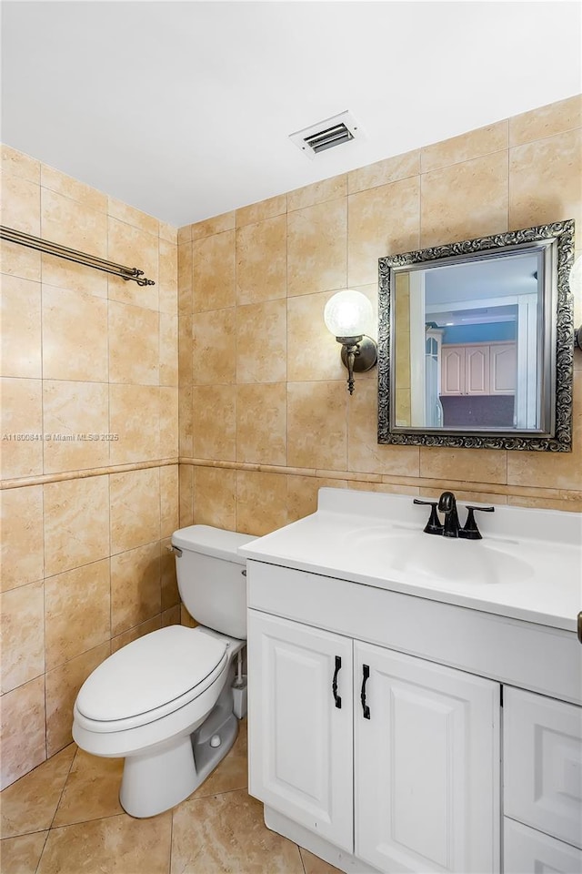 bathroom featuring tile walls, toilet, and vanity