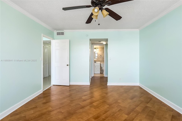 unfurnished bedroom with wood finished floors, a textured ceiling, ornamental molding, baseboards, and a ceiling fan