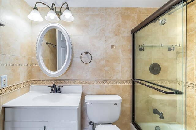 2025 NE 164th St Unit 907, North Miami Beach, FL 33162 - full bathroom featuring tile walls, a shower with door, vanity, and toilet