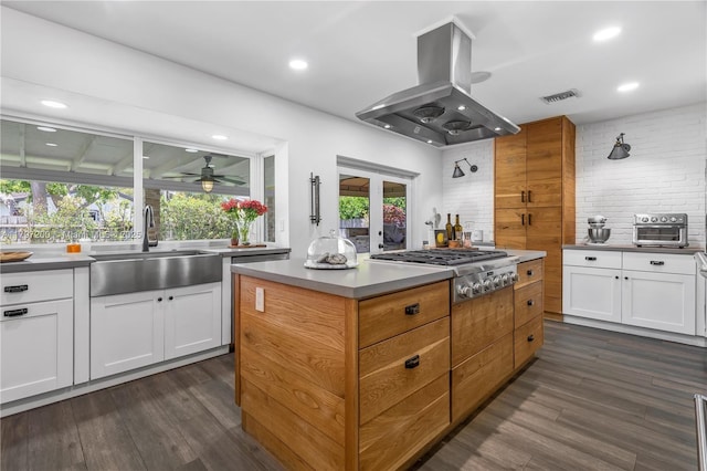9621 SW 59th Ter, Miami, FL 33173 - kitchen featuring island exhaust hood, a sink, stainless steel gas stovetop, white cabinetry, and backsplash