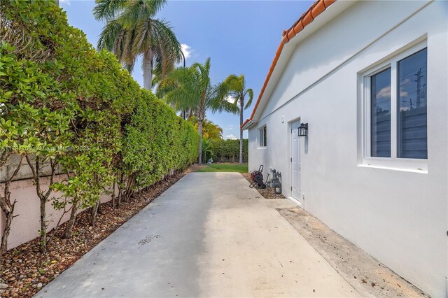 9621 SW 59th Ter, Miami, FL 33173 - view of side of home with stucco siding, a fenced backyard, and a patio