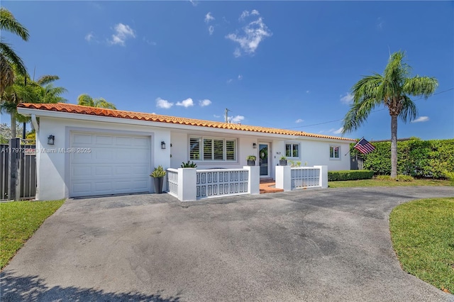 9621 SW 59th Ter, Miami, FL 33173 - view of front of house featuring stucco siding, a tiled roof, asphalt driveway, and a garage