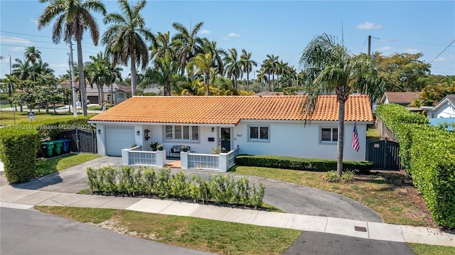 9621 SW 59th Ter, Miami, FL 33173 - view of front of home featuring asphalt driveway, an attached garage, a tile roof, and stucco siding