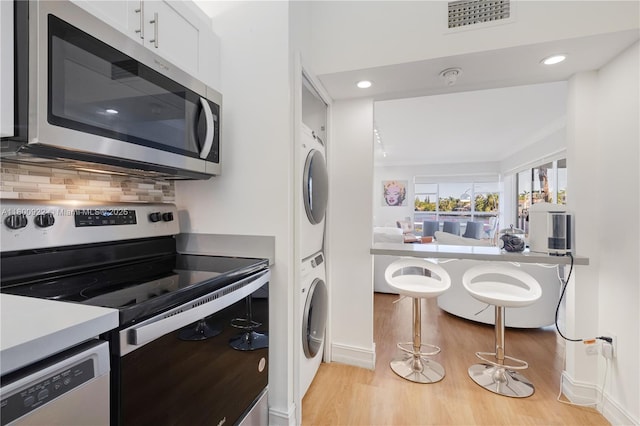 20505 E Country Club Dr Unit 143, Aventura, FL 33180 - kitchen with appliances with stainless steel finishes, estacked washer and dryer, light wood-style flooring, baseboards, and recessed lighting