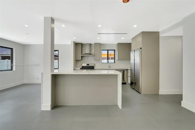 129 NE 2nd Ave, Dania Beach, FL 33004 - kitchen featuring wall chimney range hood, stainless steel appliances, gray cabinets, light countertops, and baseboards
