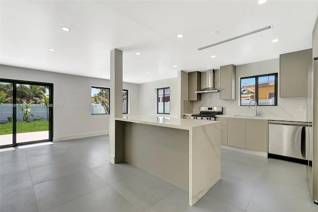 129 NE 2nd Ave, Dania Beach, FL 33004 - kitchen with wall chimney range hood, stainless steel appliances, modern cabinets, gray cabinets, and a sink