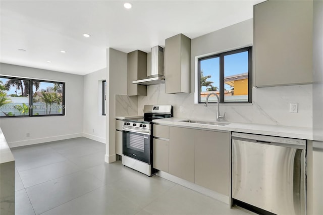 129 NE 2nd Ave, Dania Beach, FL 33004 - kitchen featuring appliances with stainless steel finishes, wall chimney exhaust hood, gray cabinets, a sink, and light countertops