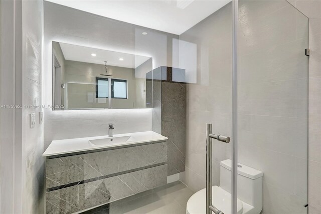 129 NE 2nd Ave, Dania Beach, FL 33004 - full bathroom with toilet, vanity, tile walls, and an enclosed shower