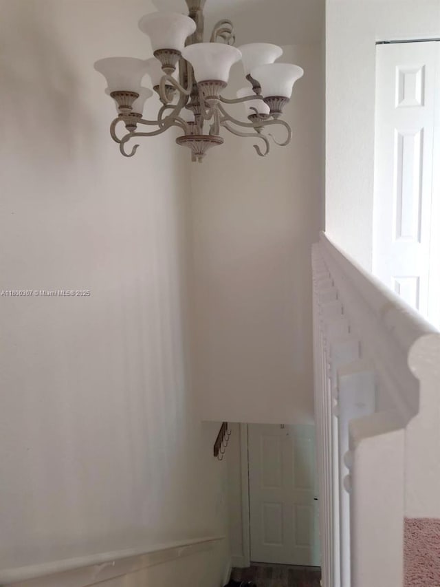 stairs featuring a chandelier