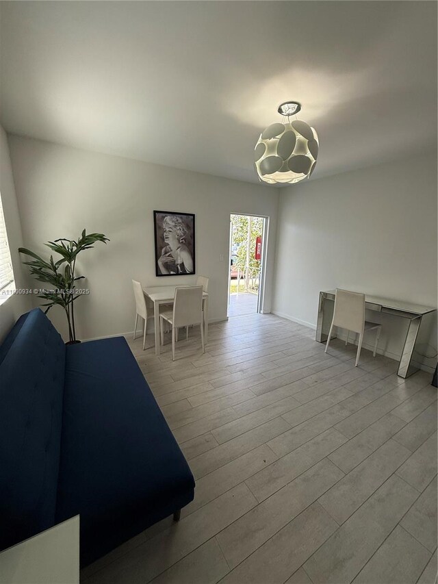 1601 Meridian Ave Unit 101, Miami Beach, FL 33139 - dining room featuring a chandelier, wood finished floors, and baseboards