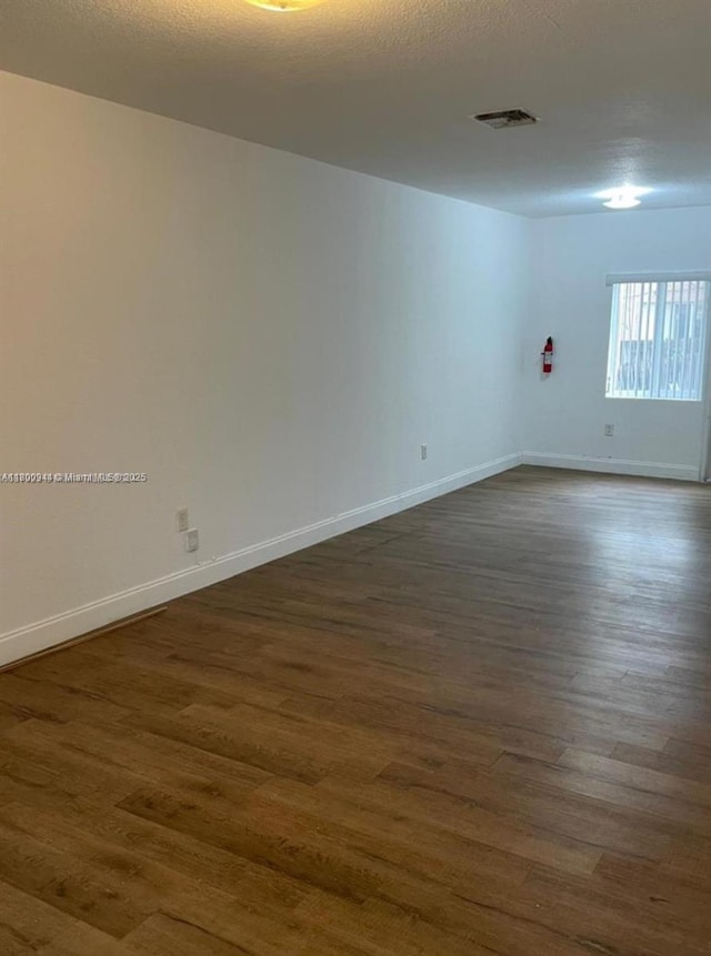 307 NW 84th St Unit 307, Miami, FL 33150 - spare room featuring dark wood-type flooring and baseboards
