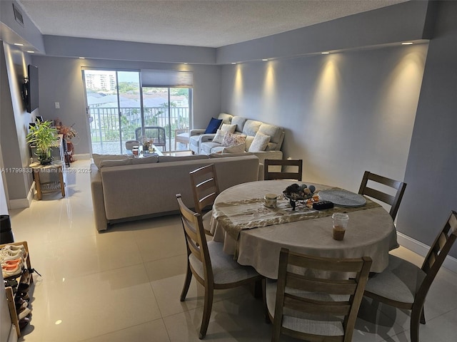 3850 Washington St Unit 704, Hollywood, FL 33021 - dining space with a textured ceiling, baseboards, and light tile patterned floors