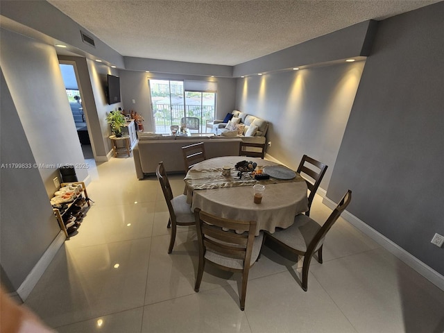 3850 Washington St Unit 704, Hollywood, FL 33021 - dining room featuring a textured ceiling, light tile patterned floors, and baseboards
