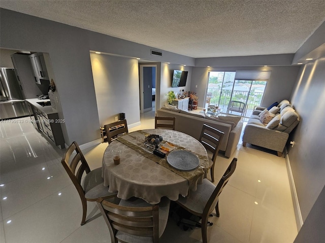 3850 Washington St Unit 704, Hollywood, FL 33021 - dining area with a textured ceiling, baseboards, and tile patterned flooring