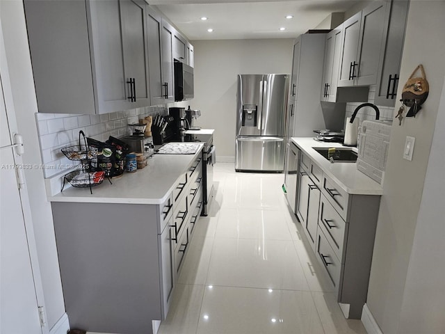 3850 Washington St Unit 704, Hollywood, FL 33021 - kitchen featuring black appliances, gray cabinetry, baseboards, decorative backsplash, and light countertops