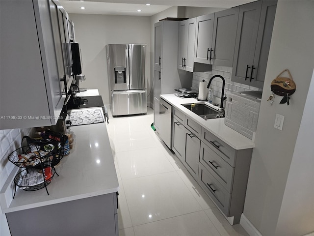 3850 Washington St Unit 704, Hollywood, FL 33021 - kitchen featuring appliances with stainless steel finishes, a sink, gray cabinetry, tasteful backsplash, and light countertops