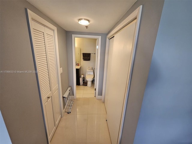 3850 Washington St Unit 704, Hollywood, FL 33021 - hall with light tile patterned floors, heating unit, and baseboards