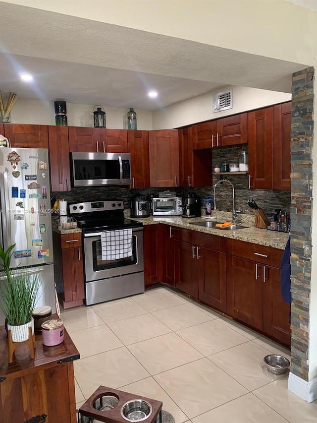 519 S 61st Ave, Hollywood, FL 33023 - kitchen with stainless steel appliances, a sink, tasteful backsplash, and light tile patterned floors