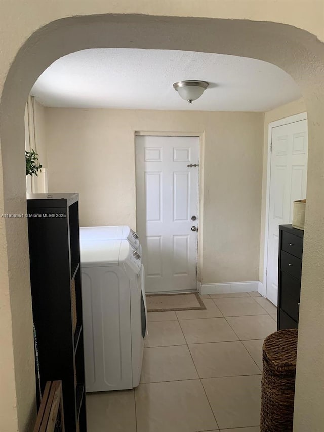 519 S 61st Ave, Hollywood, FL 33023 - laundry room featuring arched walkways, separate washer and dryer, light tile patterned floors, and baseboards