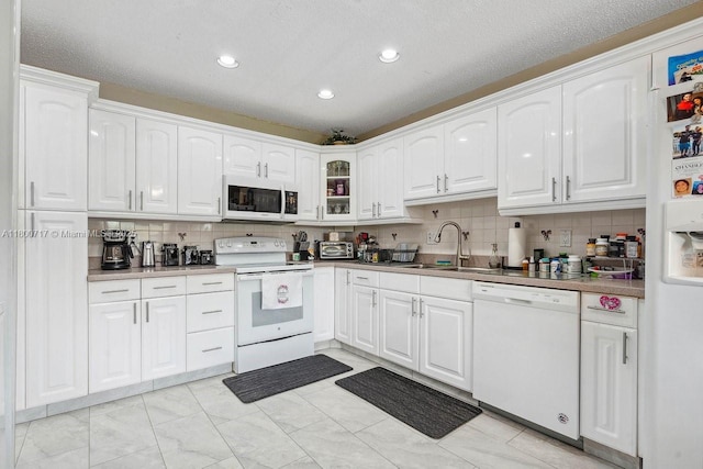 1621 NW 20th Ave Unit 203, Delray Beach, FL 33445 - kitchen featuring white appliances, tasteful backsplash, white cabinets, recessed lighting, and glass insert cabinets