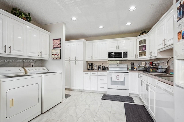 1621 NW 20th Ave Unit 203, Delray Beach, FL 33445 - laundry room featuring independent washer and dryer, recessed lighting, light marble finish floors, and a textured ceiling