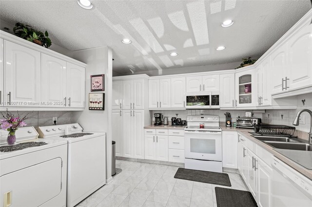 1621 NW 20th Ave Unit 203, Delray Beach, FL 33445 - kitchen with white appliances, white cabinetry, glass insert cabinets, a textured ceiling, and tasteful backsplash