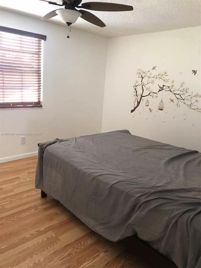 3734 NW 107th Way, Sunrise, FL 33351 - bedroom with light wood-style floors, a textured ceiling, baseboards, and ceiling fan