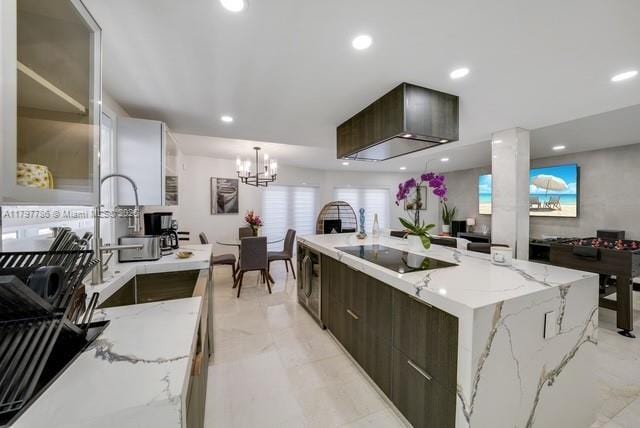 kitchen featuring black electric cooktop, modern cabinets, dark brown cabinetry, a chandelier, and a sink