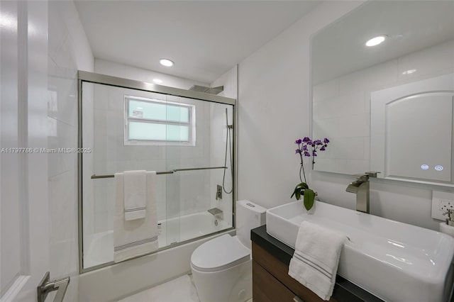 bathroom featuring enclosed tub / shower combo, toilet, vanity, and recessed lighting