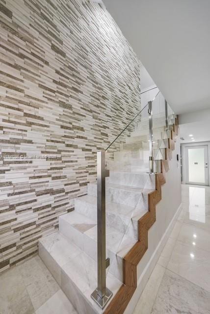 staircase featuring baseboards and marble finish flooring