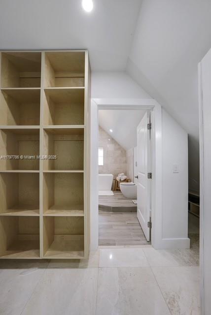 bathroom with lofted ceiling and toilet