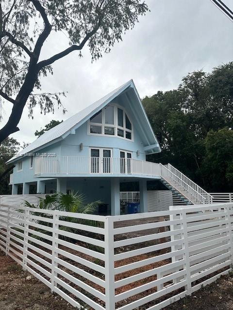 view of side of property featuring a fenced front yard, driveway, and a garage
