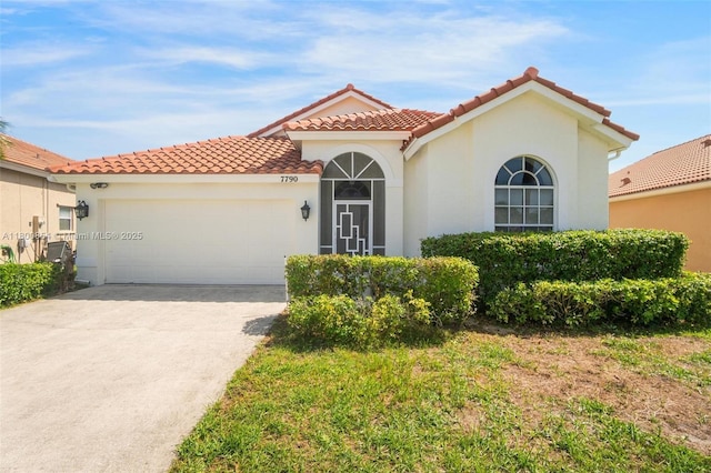 mediterranean / spanish house with a tile roof, an attached garage, stucco siding, and driveway