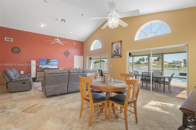 dining space with a ceiling fan, high vaulted ceiling, and healthy amount of natural light