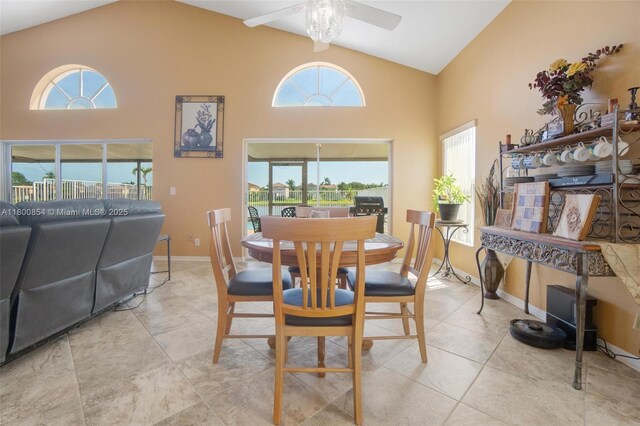 dining area with ceiling fan, high vaulted ceiling, and baseboards