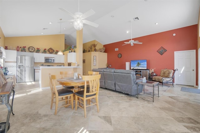 dining space with a ceiling fan and high vaulted ceiling