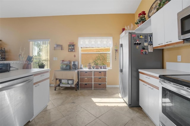 kitchen with stainless steel appliances, white cabinetry, light countertops, and light tile patterned flooring