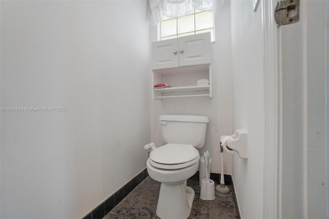 bathroom featuring toilet and baseboards