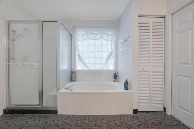 full bath with a closet, a garden tub, and a shower stall