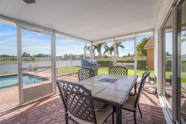 sunroom / solarium with a water view and outdoor dining space