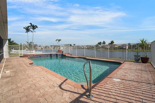 view of pool with a patio area, fence, and a water view