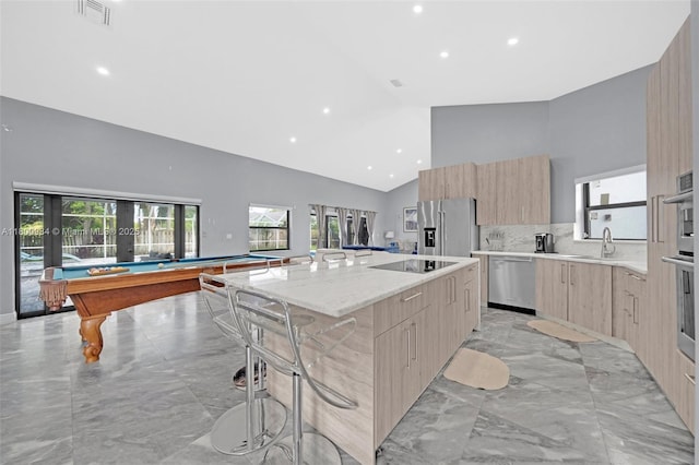 5260 NW 74th Ter, Lauderhill, FL 33319 - kitchen featuring modern cabinets, stainless steel appliances, high vaulted ceiling, light brown cabinets, and light marble finish floors